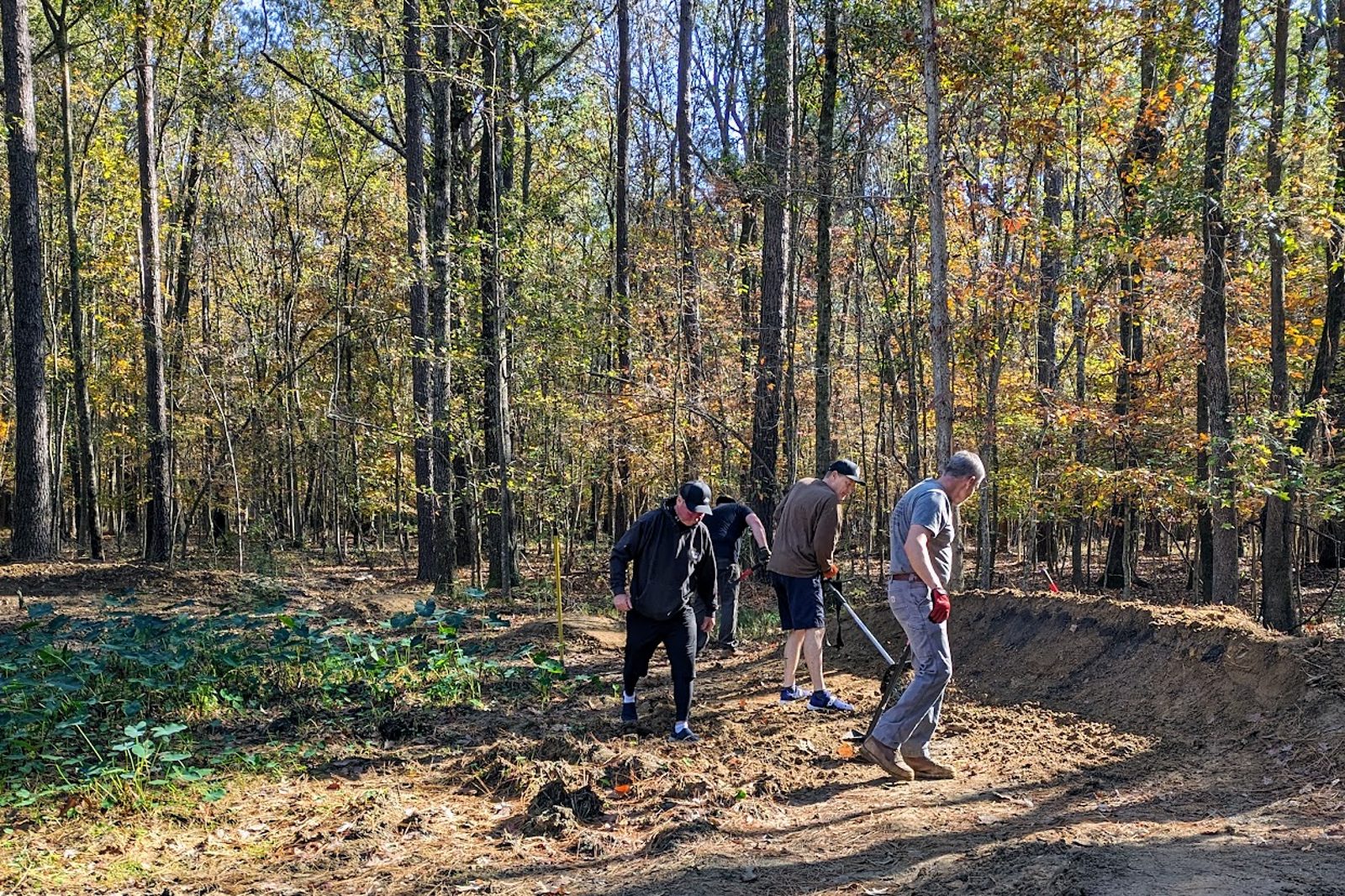 Trail crew shaping a berm and clearing the tread